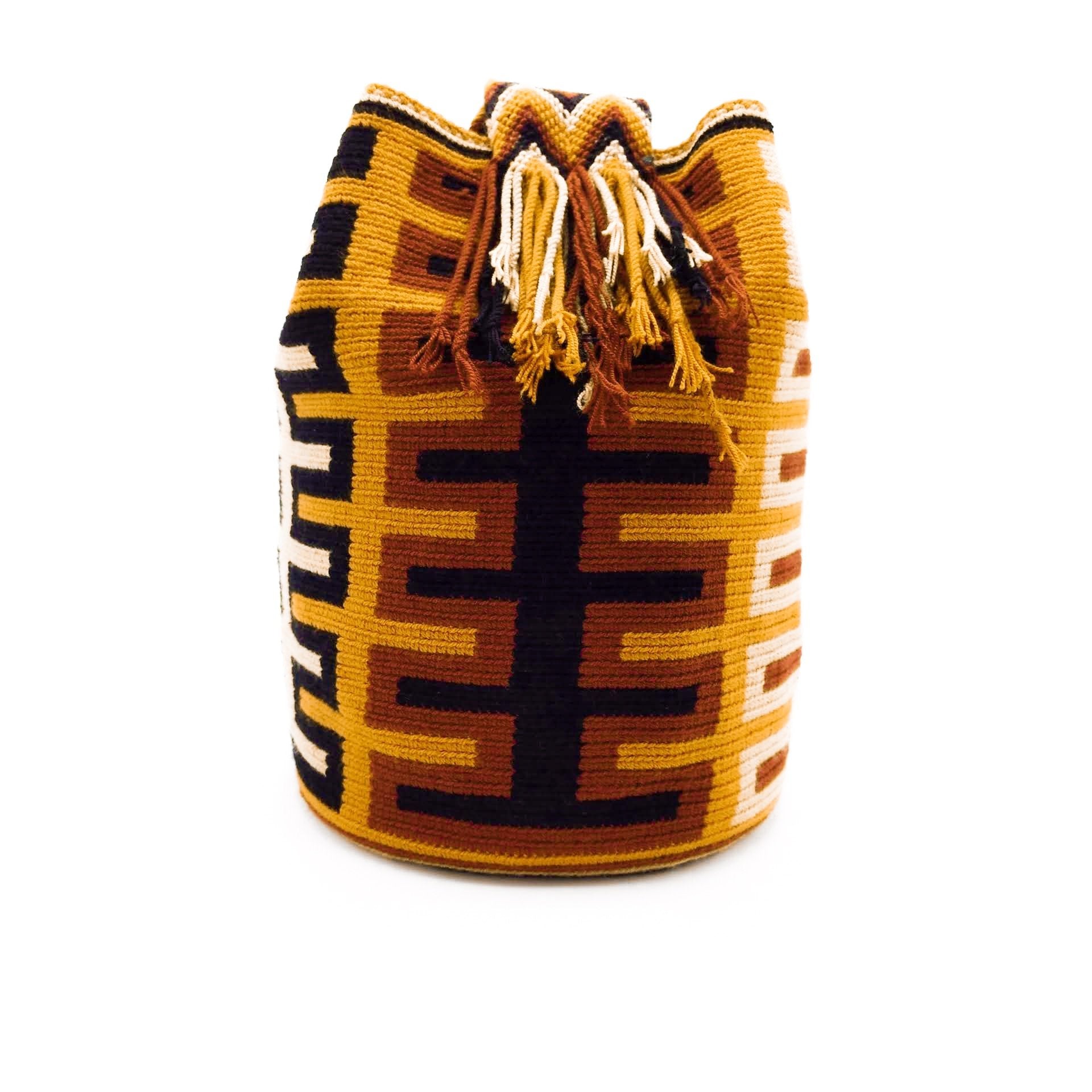 Side view of a pretty Wayuu Mochila bag with an awesome pattern in earthy colors such as Amber, Tan, Carmine, and Black