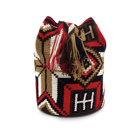 Side view of a beautiful Wayuu Mochila Bag with a vibrant pattern in colors Ivory, Bright-Red, Light-Brown, Dark-Brown, and Black.